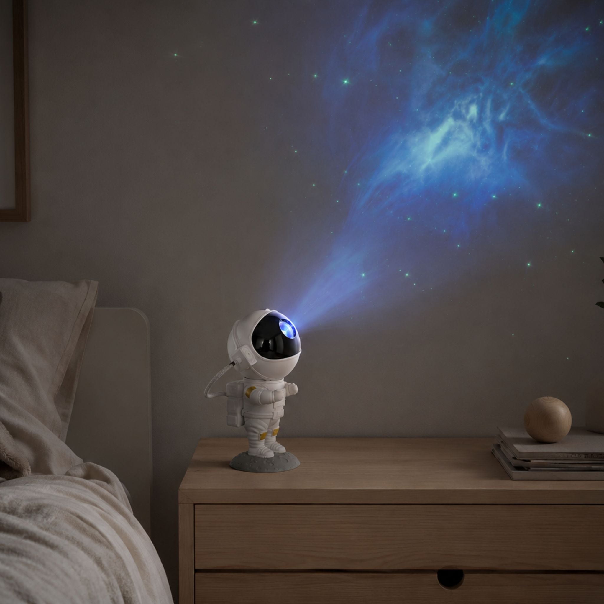 Astronaut galaxy projektor på nattduksbord som projicerar stjärnhimmel och galax på väggen i ett mysigt skandinaviskt barnrum