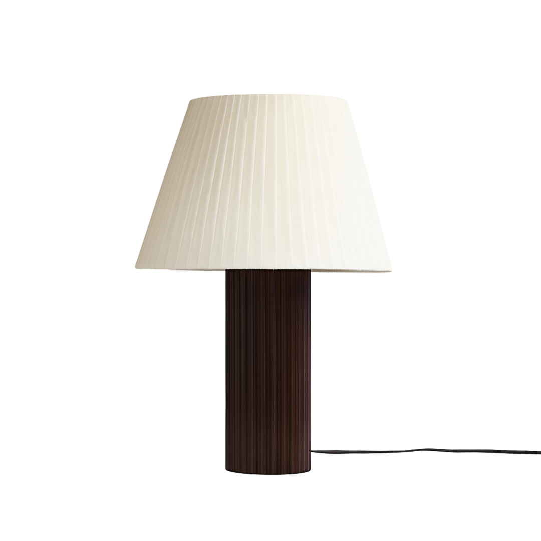 Bordslampa Aristo med veckad vit lampskärm och räfflad fot i mörkt trä, tidlös design för vardagsrum och sovrum.