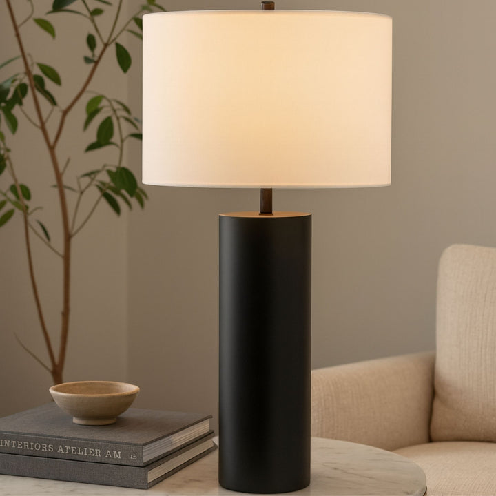 Bordslampa Atlas med vit tygskärm placerad på sidobord i vardagsrum med mjuka naturtoner