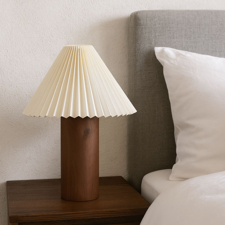 Bordslampa Cask på sängbord i lugnt sovrum med varma naturtoner