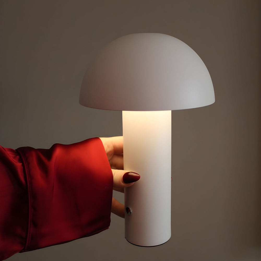 De Mesa portabel bordslampa i vit finish som hålls i hand och lyser med mjukt ljus, i modern och stilren design.