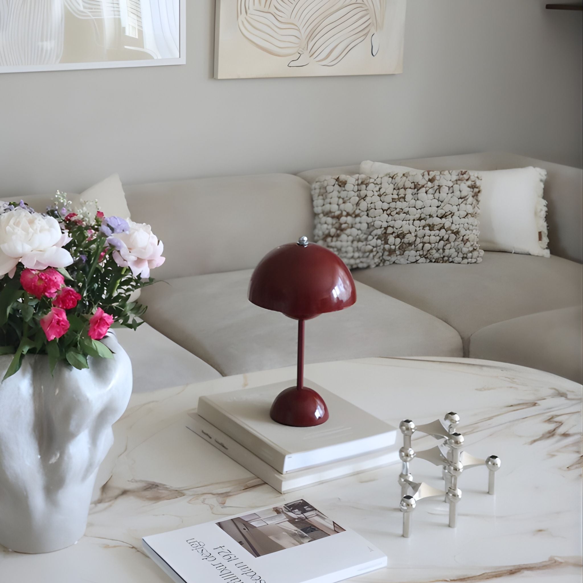 Flowerbud bordslampa i röd finish med rund skärm, placerad på soffbord i elegant vardagsrum med ljusa toner och skandinavisk inredning.