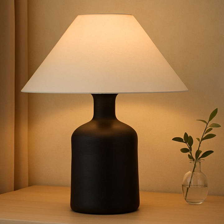 Bordslampa Kura placerad på träbyrå i naturligt ljus med tidlös skandinavisk känsla