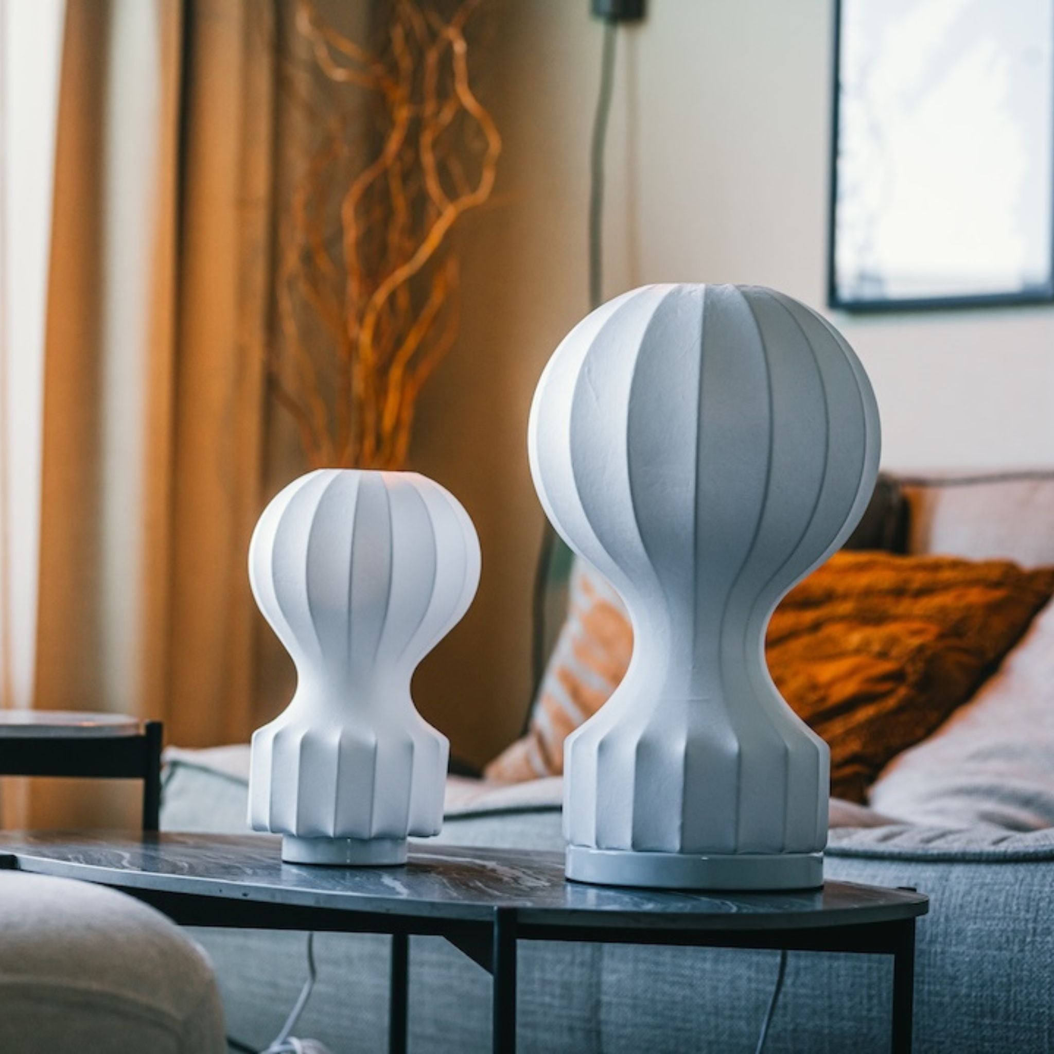 Bordslampa Luftballong i två storlekar placerade på soffbord i skandinaviskt vardagsrum