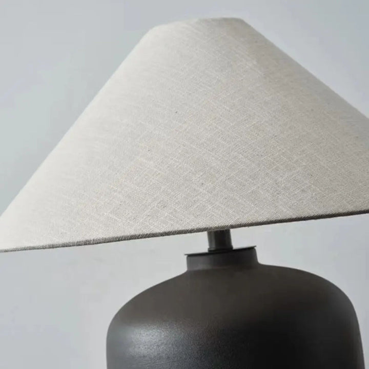 Detaljbild av bordslampa Noir med matt svart keramisk lampfot och elegant lampskärm