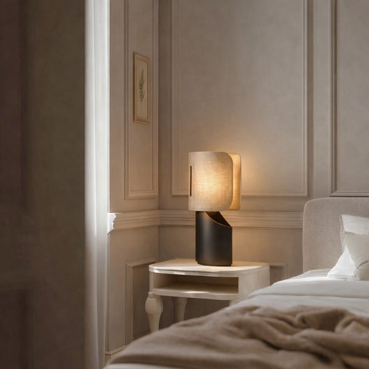 Bordslampa Panelo tänd på sängbord i sovrum med beige väggar och mjuk hotellkänsla
