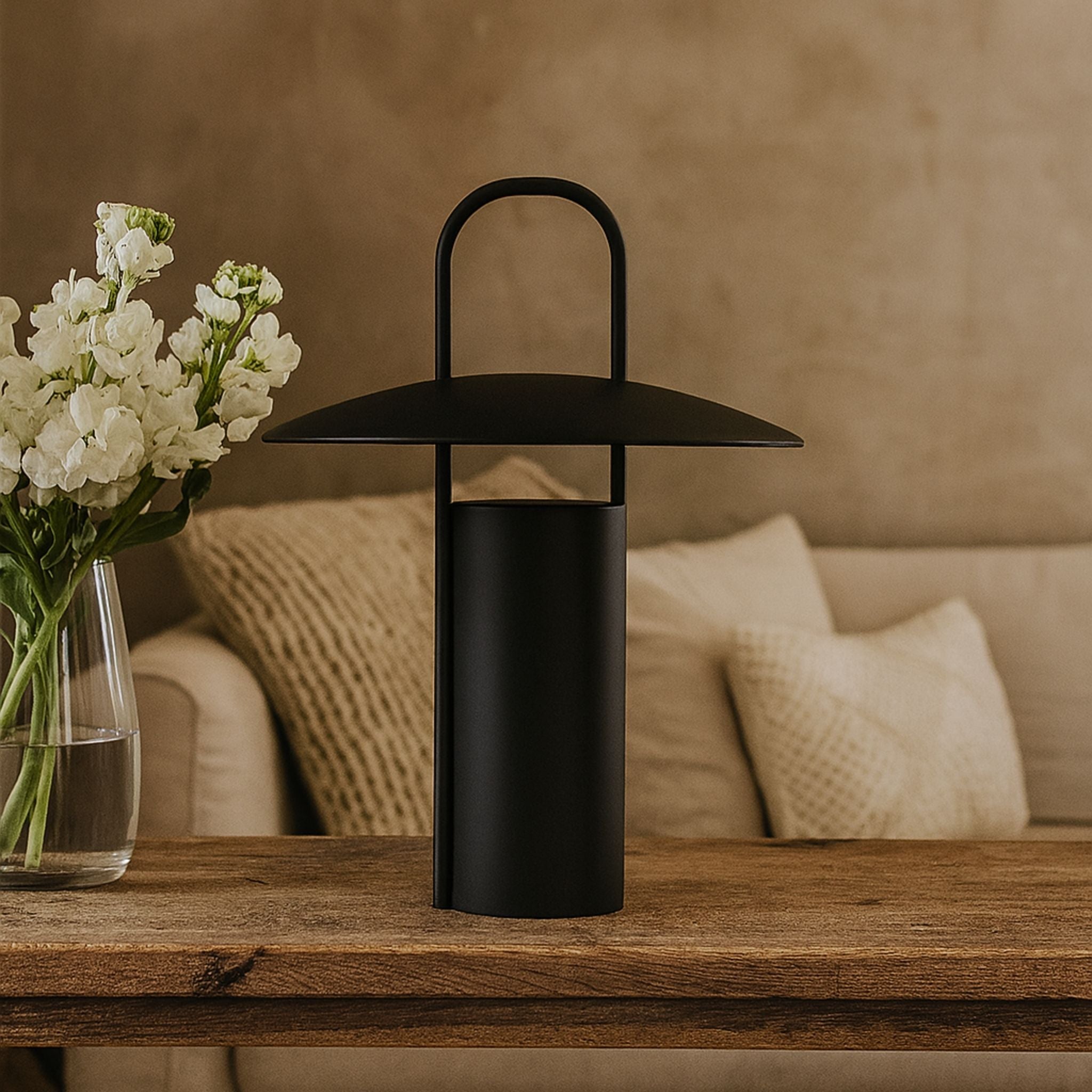 Svart portabel bordslampa Porto placerad på träbord i vardagsrum 
