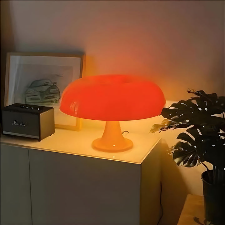 Orange retro bordslampa placerad på sidobord som ger varmt och stämningsfullt ljus i vardagsrum