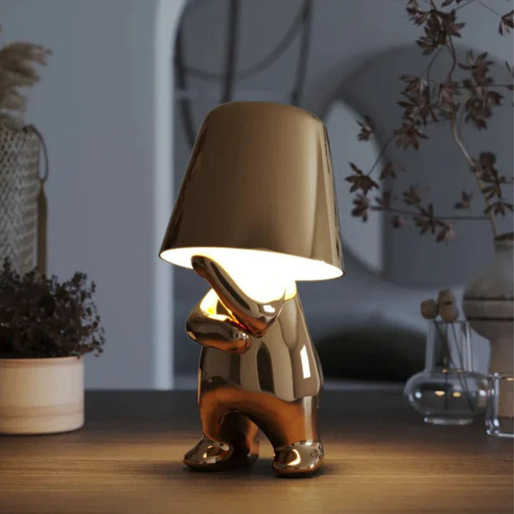 Guldfärgad bordslampa Thinker i modern inredning – dekorativ designlampa med varm ljussättning