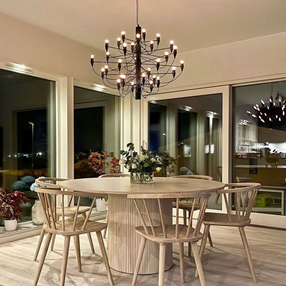 Elegant Ljuskrona 30 i svart placerad över runt matbord i modern matsal med varm och stämningsfull belysning