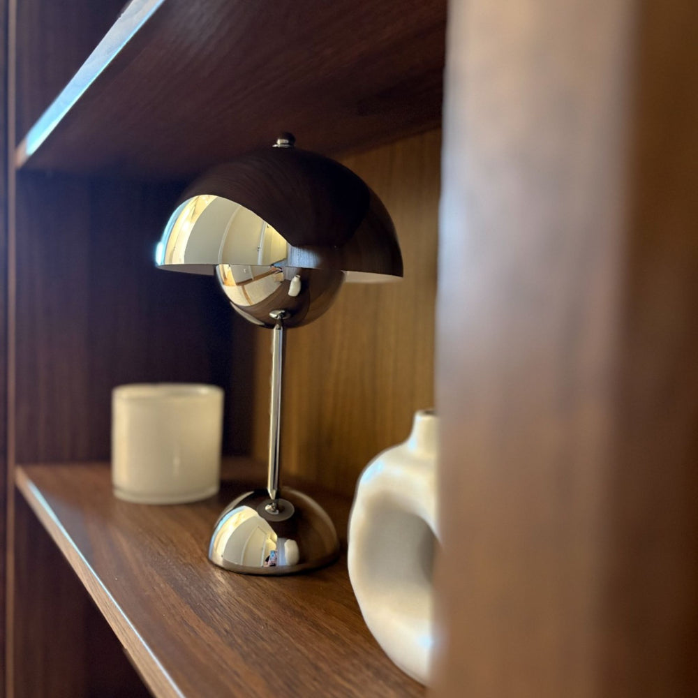 flowerbud bordslampa i krom på hylla med varm belysning i modern skandinavisk inredning
