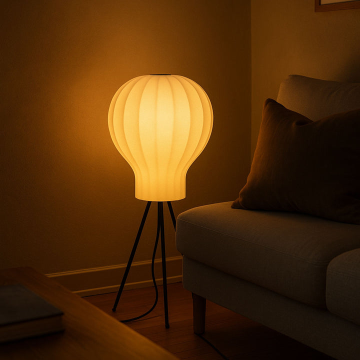 Golvlampa Bubble bredvid soffa i kvällsmiljö som ger varm mysbelysning och ett ombonat intryck i rummet.