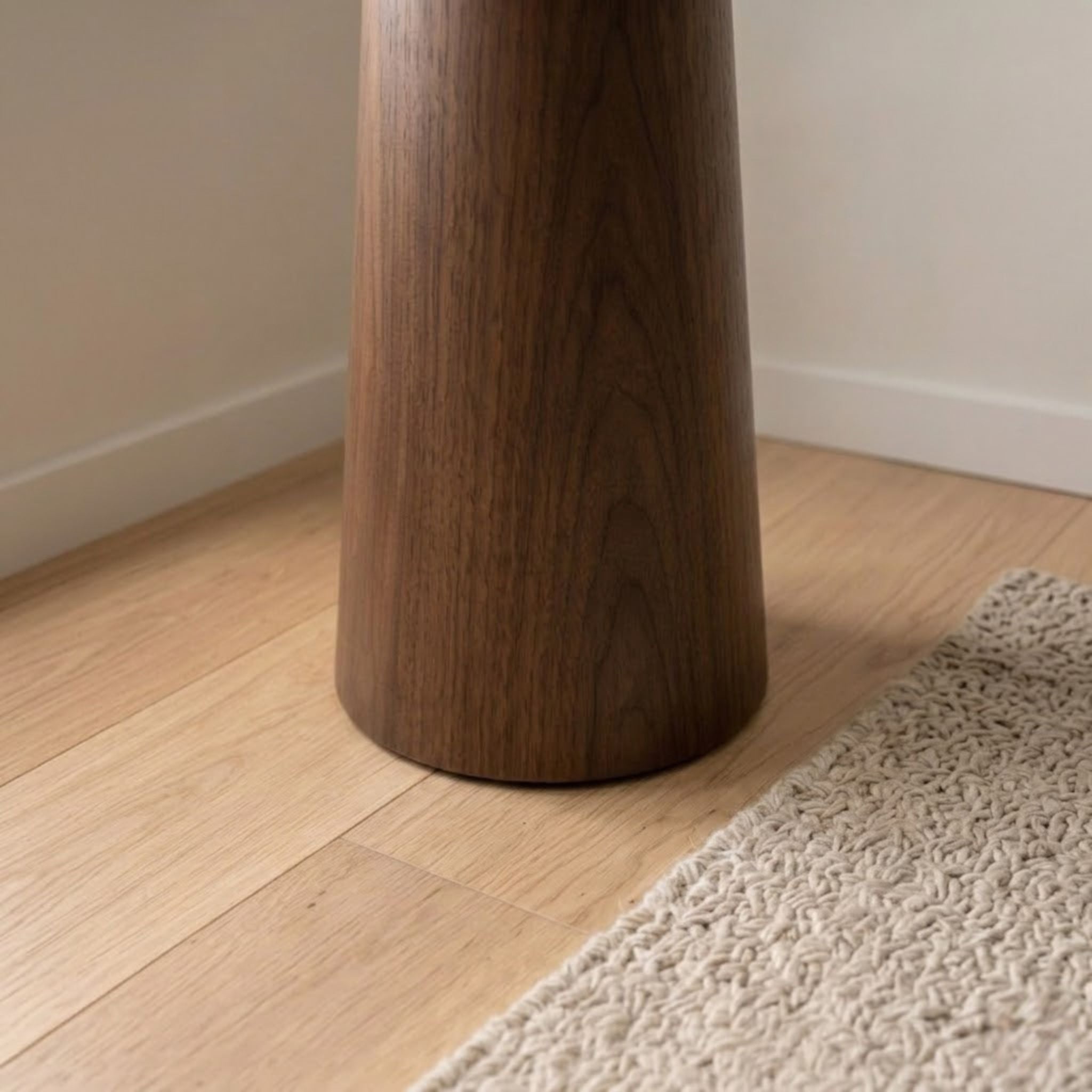 Detaljbild av golvlampa Timber med konformad bas i trä och naturlig trästruktur