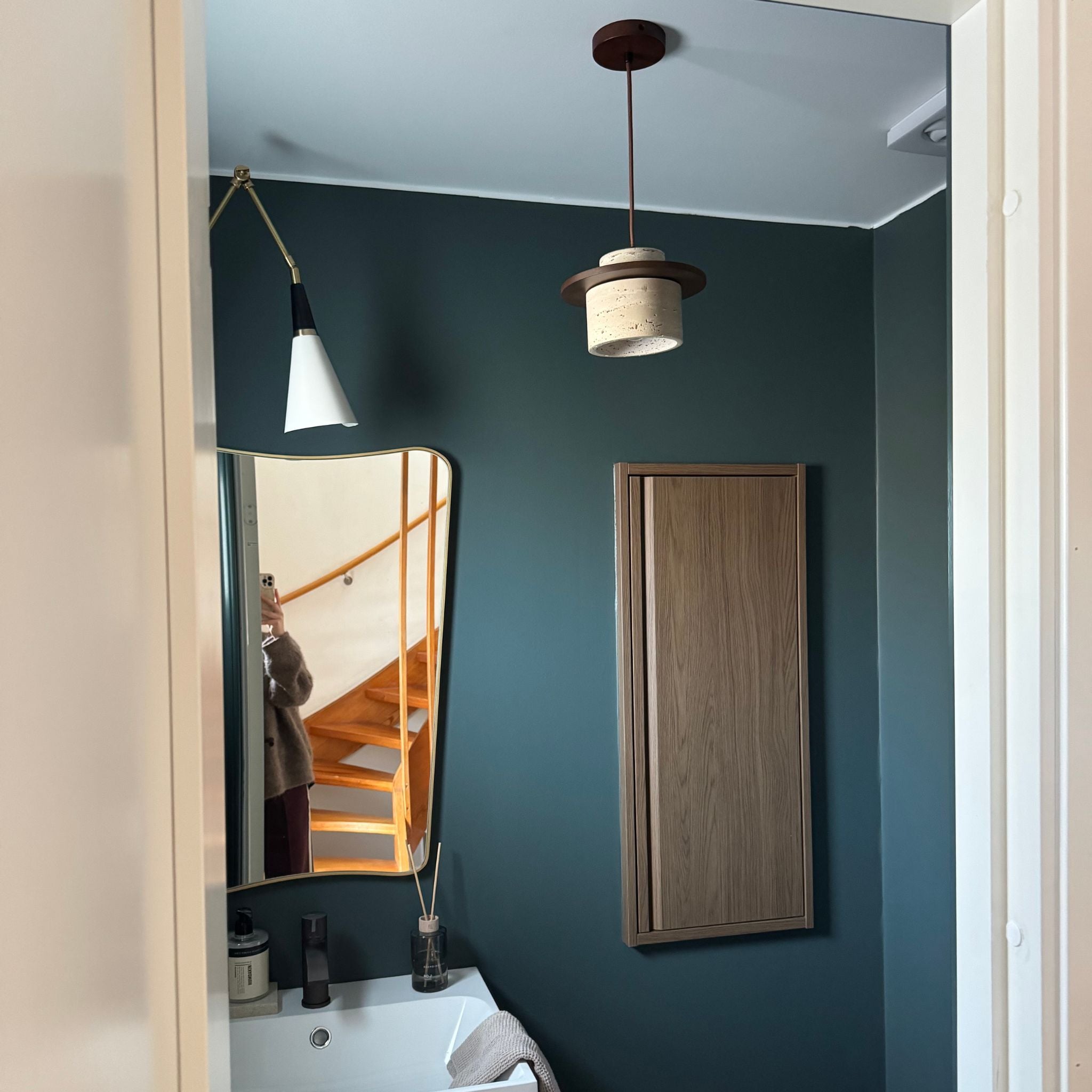 Kanso pendellampa i travertin och trä monterad i badrum med stilren nordisk design