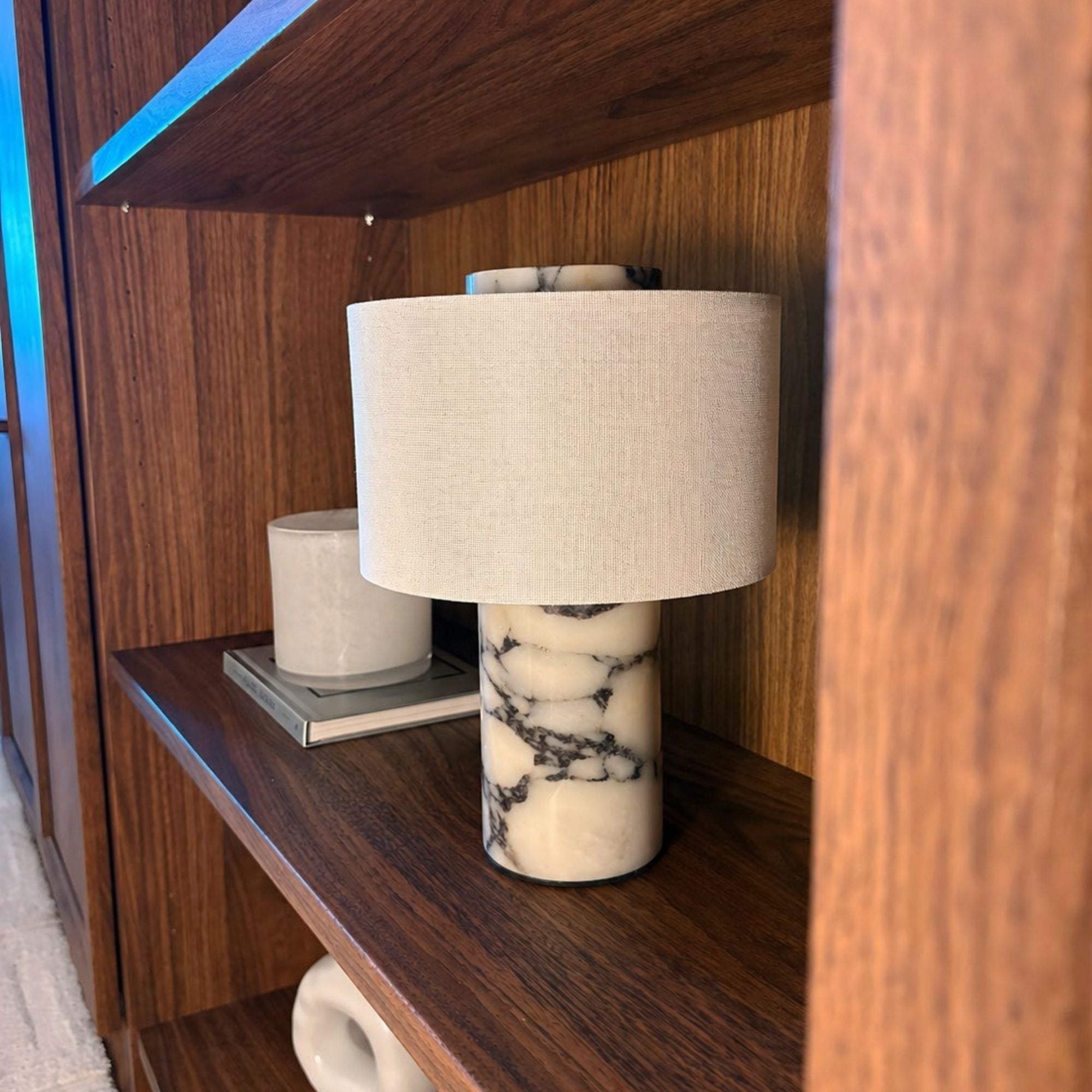 Monolit bordslampa i marble natursten med textilskärm på hylla, modern portabel belysning i varm miljö