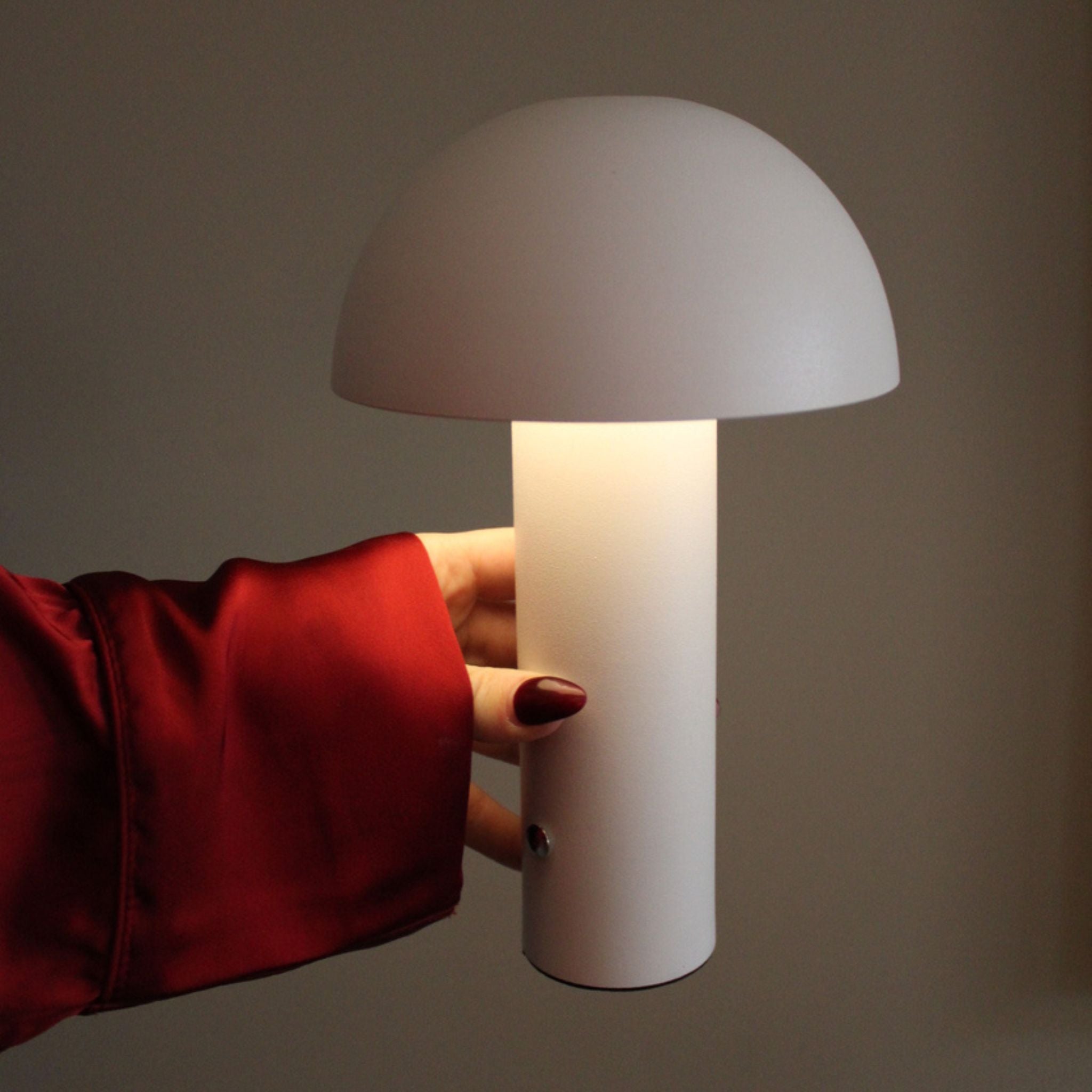 Portabel bordslampa i vit minimalistisk design med mjuk LED-belysning, hålls i hand och passar för modern och stilren inredning