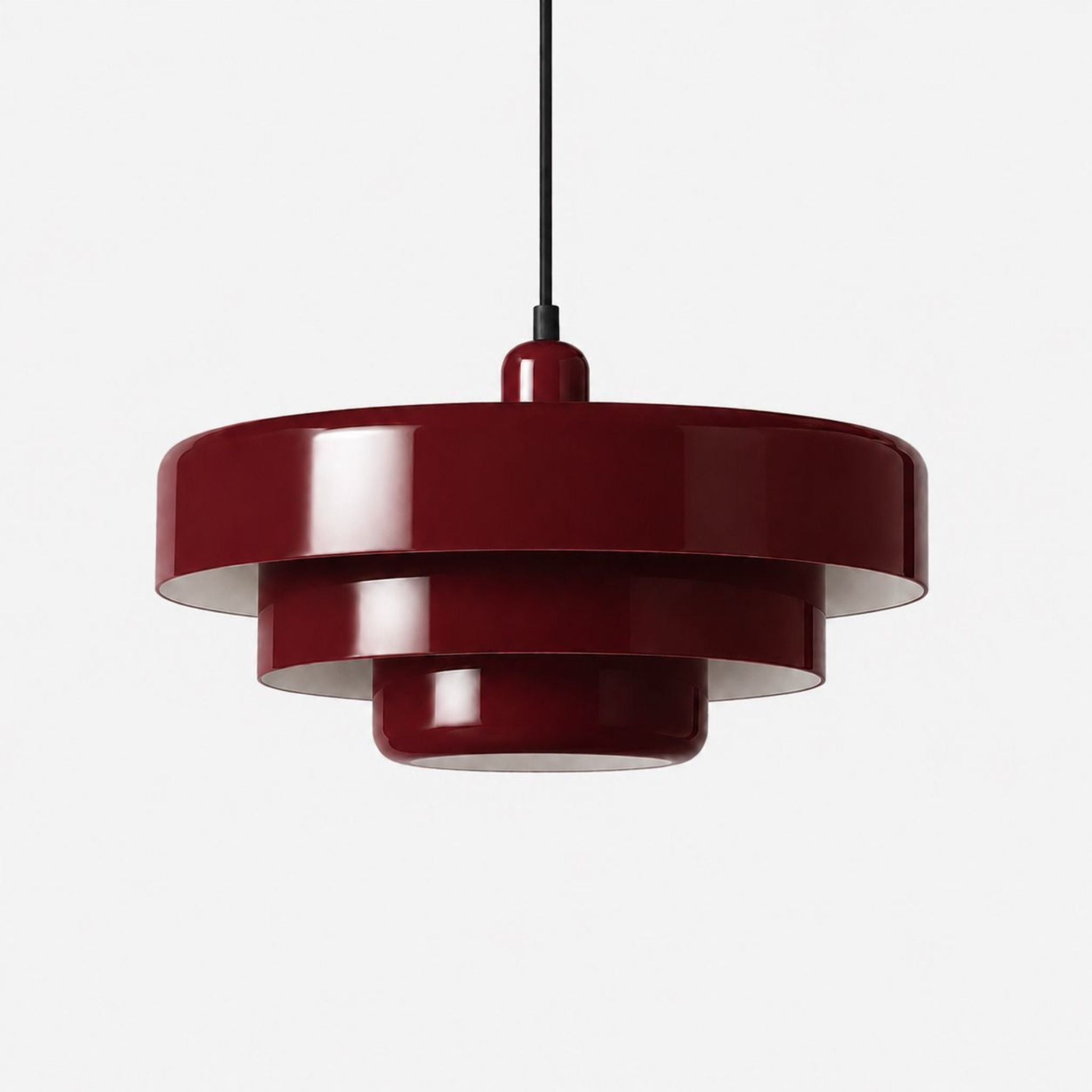 Röd glansig taklampa i retrodesign med rund skärm och svart sladd mot ljus bakgrund