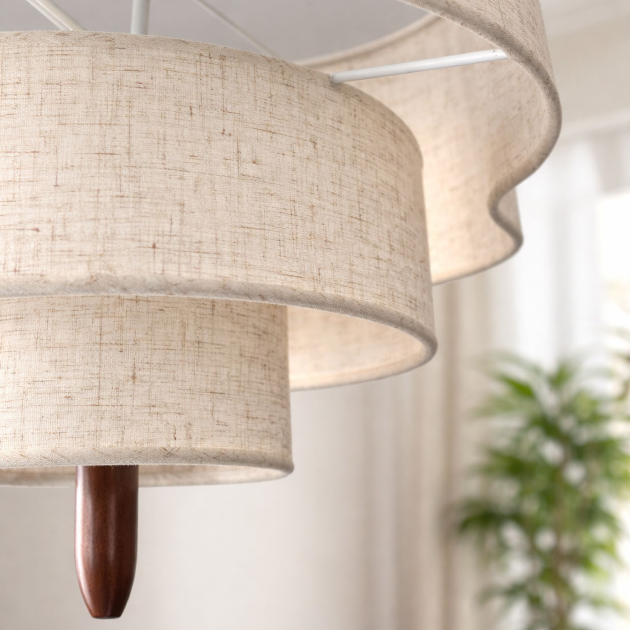 Närbild på Rondo taklampa med beige tygskärm, lager på lager-design och varm belysning
