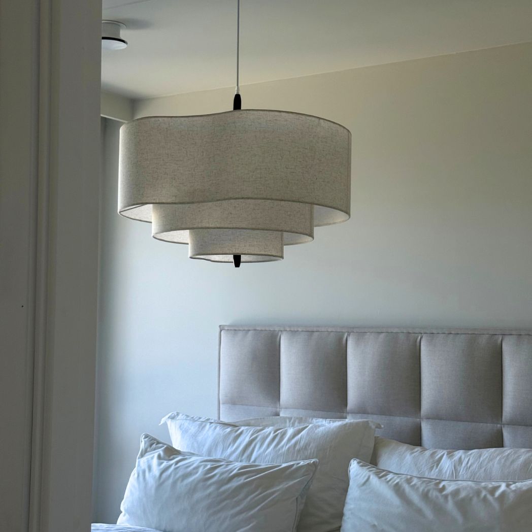 Rondo taklampa i beige textil ovanför säng i skandinaviskt sovrum