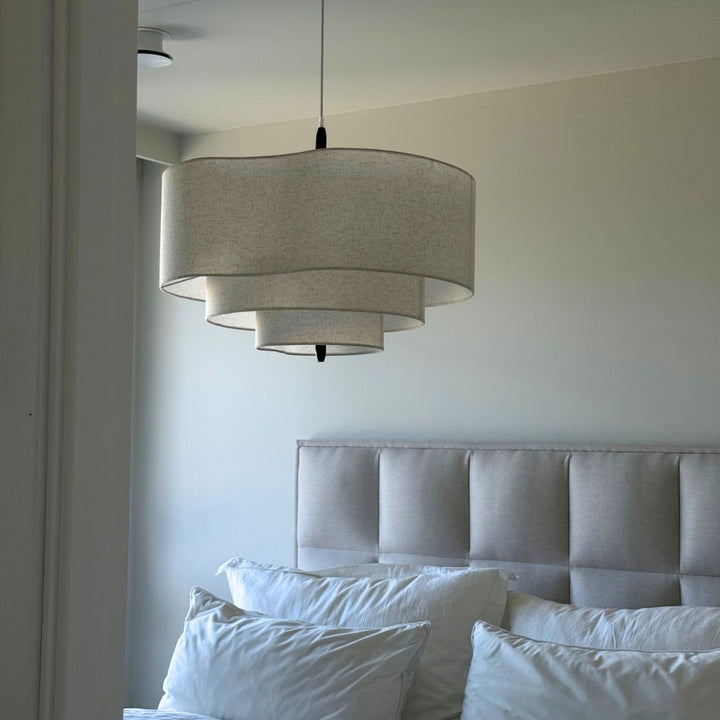 Rondo taklampa i beige textil ovanför säng i skandinaviskt sovrum