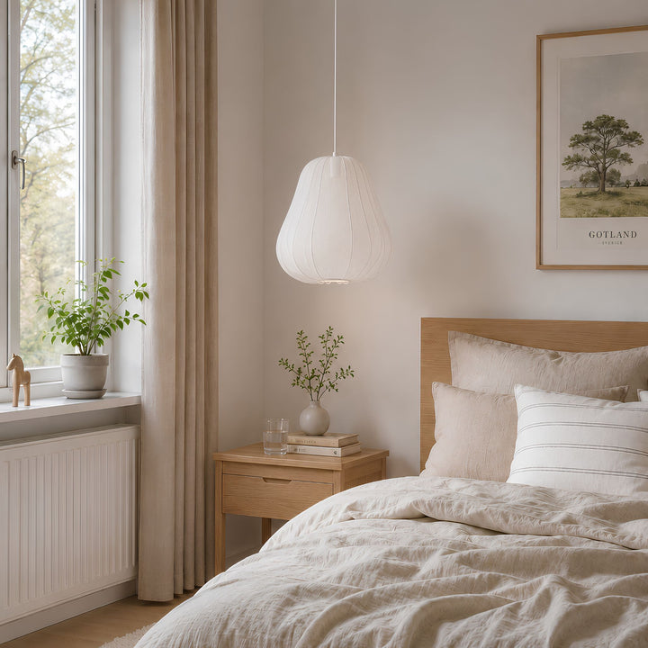 Vit Sfera taklampa i 46 cm placerad över ett nattduksbord i ett ljust skandinaviskt sovrum med trädetaljer och beige textilier