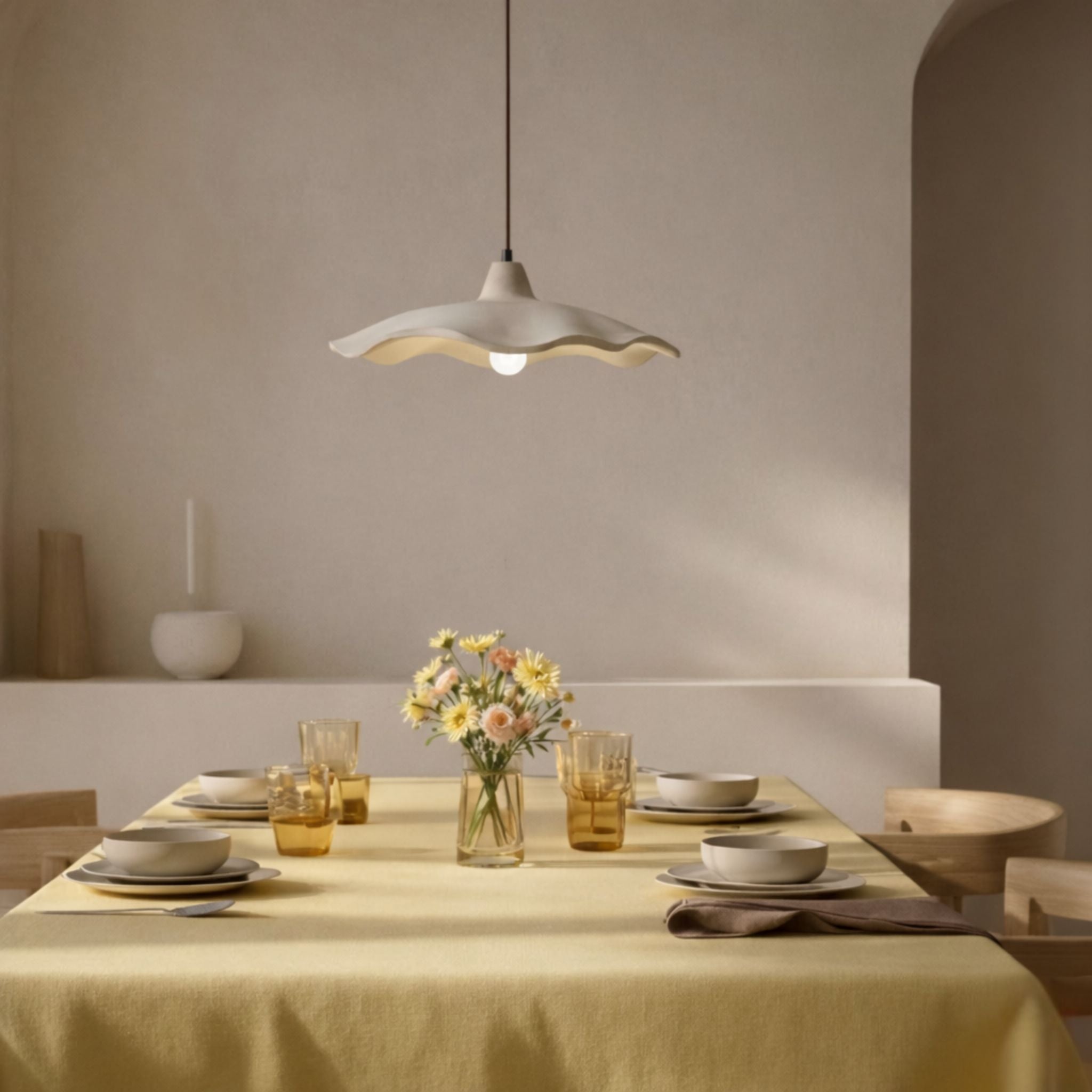 Taklampa Aladin med vågig organisk form i ljus finish, stilren skandinavisk taklampa ovanför dukat matbord i varmt inrett rum