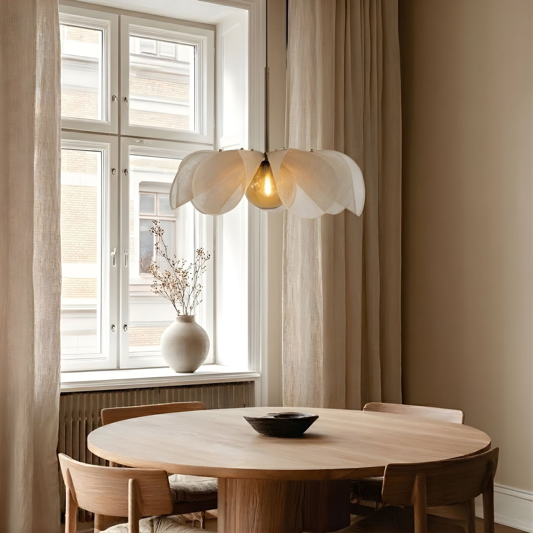 Sailing taklampa i vit organisk form ovanför träbord