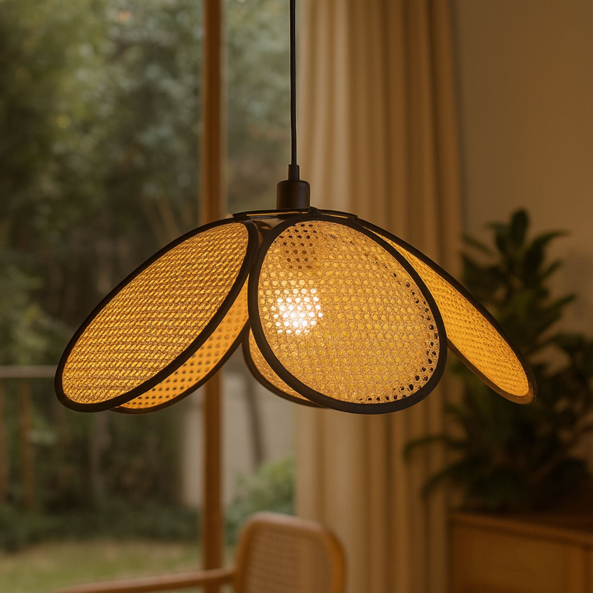 Taklampa Calima tänd i rotting placerad i inomhusmiljö vid fönster