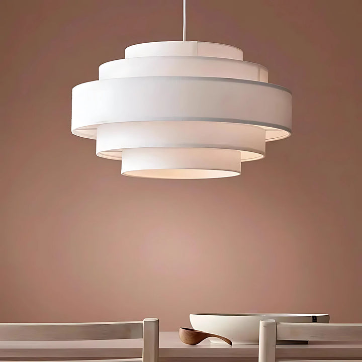 Taklampa Helix mot varm rosa vägg ovanför matbord i modern inredning