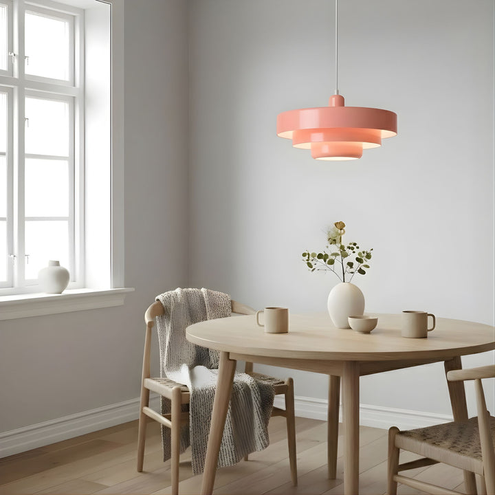 Italia taklampa i rosa finish hängande över runt matbord med stolar i ljus och stilren skandinavisk inredning med mjuka färgtoner.