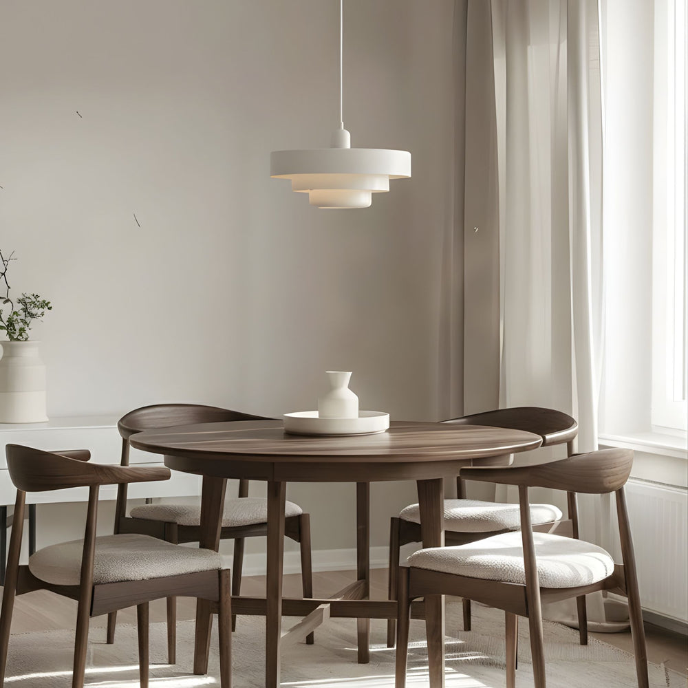 Vit taklampa Italia i modern skandinavisk design ovanför runt matbord i trä – stilren pendellampa som sprider mjukt och behagligt ljus i matplats.