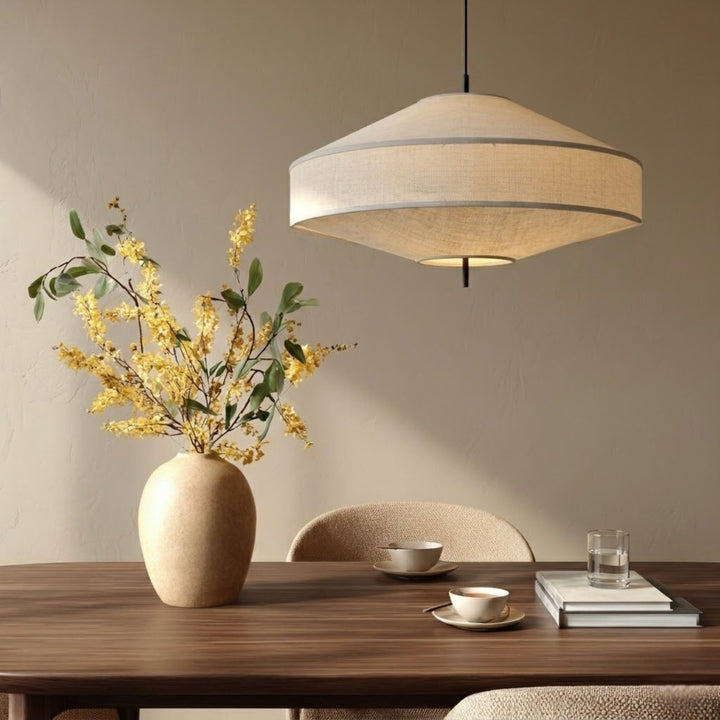 Pagoda taklampa i beige textil hängande över matbord med vas och blommor i en stilren och varm skandinavisk inredning.