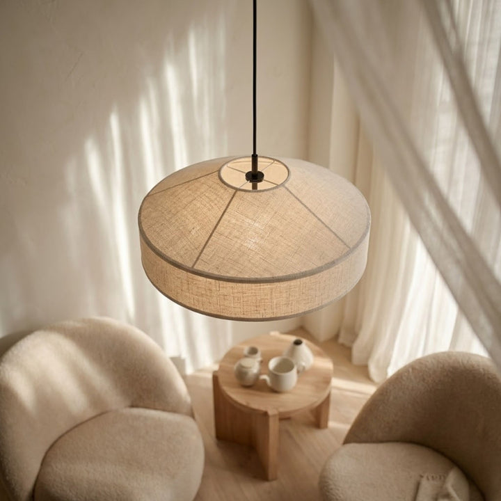 Pagoda taklampa i beige textil med mjuk rund form hängande ovanför sittgrupp med fåtöljer i en varm och harmonisk skandinavisk miljö.