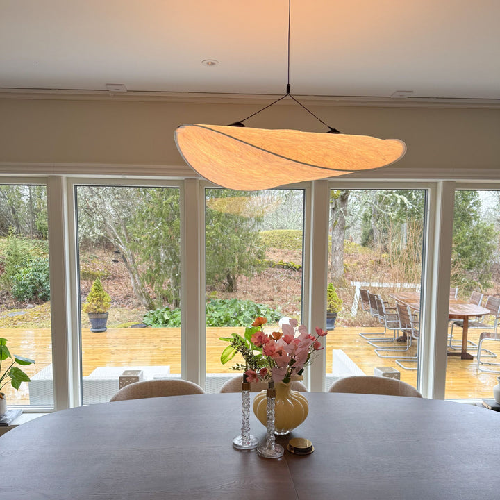 Sailing taklampa i modern organisk design ovanför matbord, stilren skandinavisk inredning med stora fönster och naturligt ljus