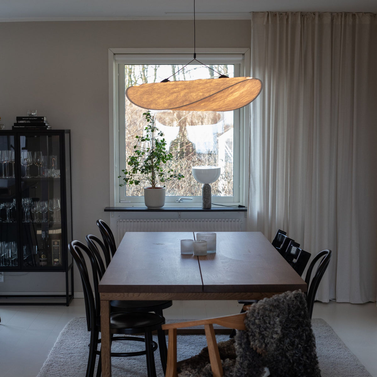 Sailing taklampa i vit organisk design hängande ovanför träbord i ljus skandinavisk matplats