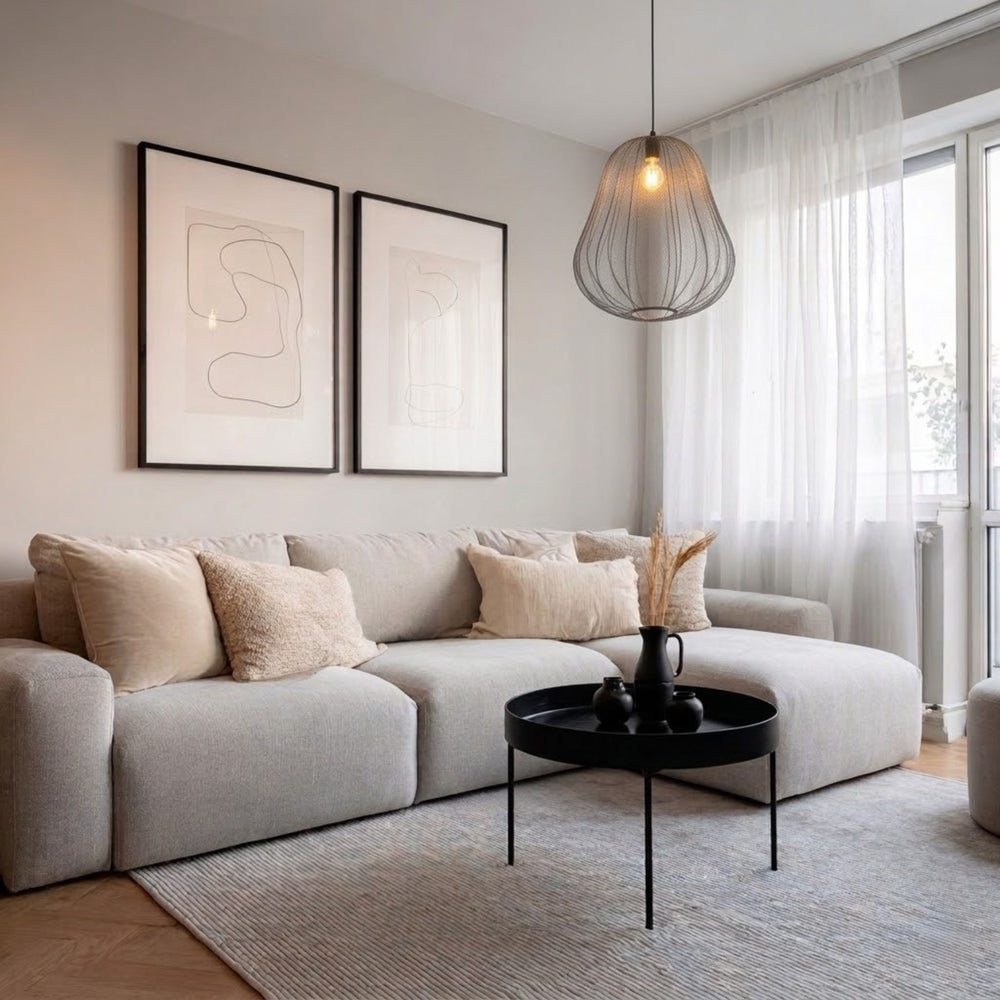 Sfera alta taklampa med rund form i grå textilskärm hängande över soffbord i ljust vardagsrum med soffa, mjuka textilier och skandinavisk inredning.