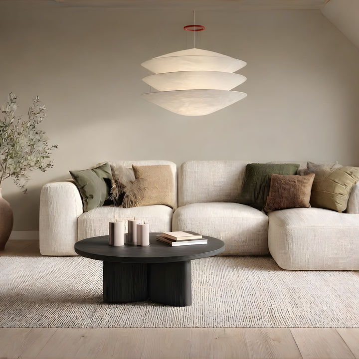 Taklampa Stratus med tre mjuka lager i vit design som hänger över soffbord i stilrent skandinaviskt vardagsrum med beige soffa och minimalistisk inredning.