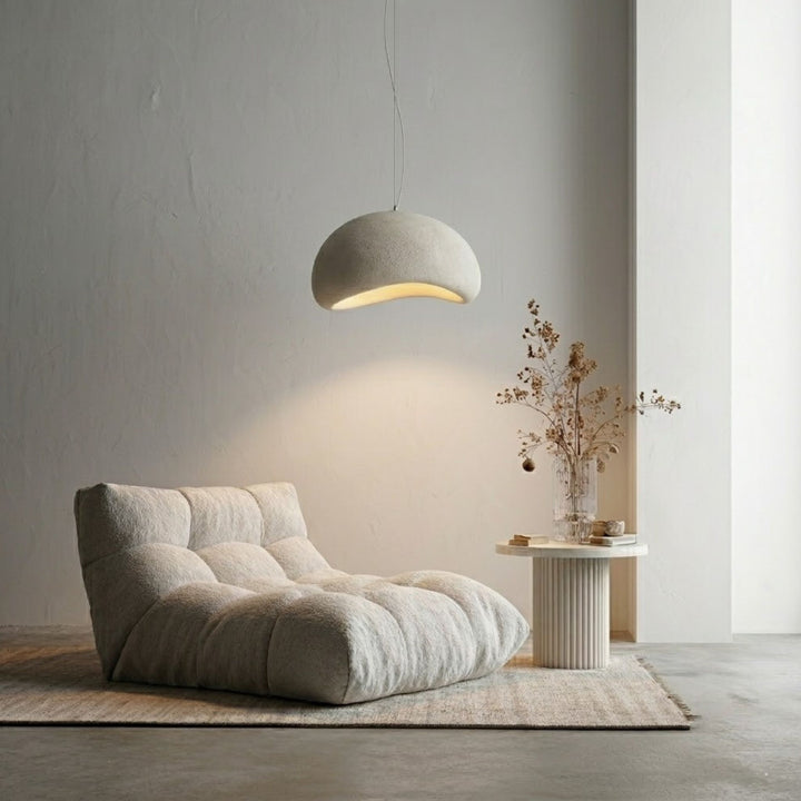 Wabi Sabi Arch 40cm taklampa - mjuk organisk form hängande över loungefåtölj i en lugn och minimalistisk skandinavisk miljö.