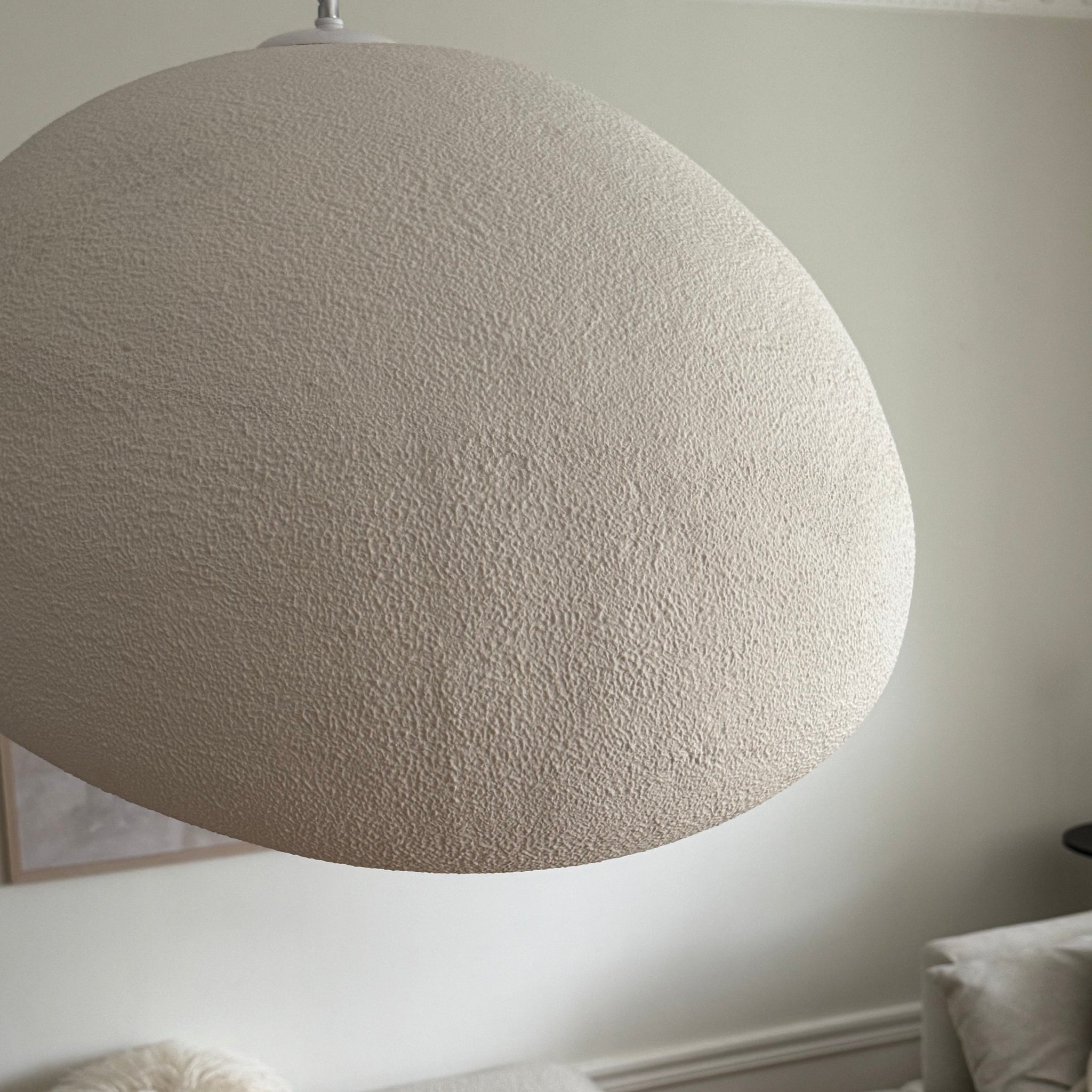 Närbild av Wabi Sabi Arch taklampa med strukturerad yta och mjuka organiska former i beige finish